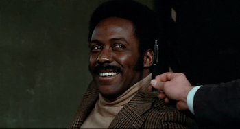 Movie still from “Shaft” (1971), directed by Gordon Parks – A man is smiling while holding a cell phone to his ear; Close Up shot, Low angle