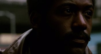 Movie still from “Shaft” (1971), directed by Gordon Parks – A man's face in the dark; Close Up shot, Low angle