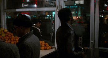Movie still from “Shaft” (1971), directed by Gordon Parks – A group of people standing around a counter; Wide shot, Over the shoulder angle