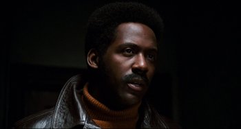 Movie still from “Shaft” (1971), directed by Gordon Parks – A person wearing a leather jacket; Close Up shot, Low angle