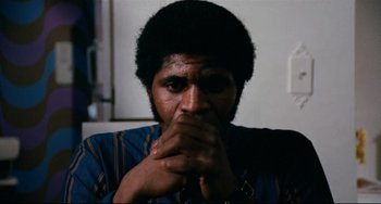 Movie still from “Shaft” (1971), directed by Gordon Parks – A man with his hands near his face; Close Up shot, Low angle