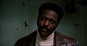Movie still from “Shaft” (1971), directed by Gordon Parks – A person wearing a leather jacket; Close Up shot, Low angle