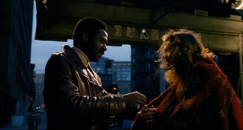 Movie still from “Shaft” (1971), directed by Gordon Parks – A man and a woman standing next to each other on the street; Medium shot, Over the shoulder angle