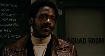 Movie still from “Shaft” (1971), directed by Gordon Parks – A man in a brown leather jacket looking at the camera; Close Up shot, Low angle