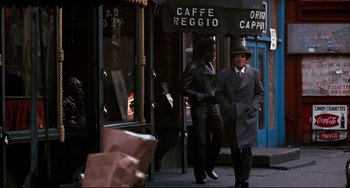 Movie still from “Shaft” (1971), directed by Gordon Parks – Two men walking down the street in front of caffe reggio; Wide shot, Over the shoulder angle