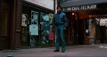 Movie still from “Shaft” (1971), directed by Gordon Parks – A man standing on the sidewalk in front of a store; Wide shot, Low angle