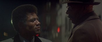 Movie still from “Shaft's Big Score!” (1972), directed by Gordon Parks – A man and a woman talking to each other; Close Up shot, Over the shoulder angle