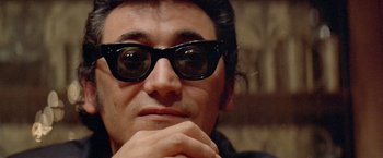 Movie still from “Shaft's Big Score!” (1972), directed by Gordon Parks – A person wearing a pair of sunglasses; Close Up shot, Low angle