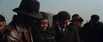 Movie still from “Shaft's Big Score!” (1972), directed by Gordon Parks – A group of people standing next to each other on a field; Medium shot, High angle