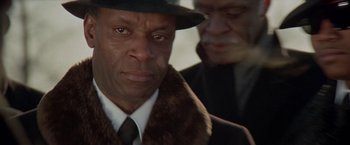 Movie still from “Shaft's Big Score!” (1972), directed by Gordon Parks – A man wearing a hat and a fur collar; Close Up shot, Over the shoulder angle