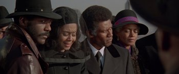 Movie still from “Shaft's Big Score!” (1972), directed by Gordon Parks – A man and a woman crying in front of a crowd; Medium shot, High angle