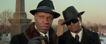 Movie still from “Shaft's Big Score!” (1972), directed by Gordon Parks – Two men in hats and coats posing for a picture; Close Up shot, Low angle