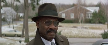 Movie still from “Shaft's Big Score!” (1972), directed by Gordon Parks – An older man wearing a hat and glasses; Close Up shot, Low angle