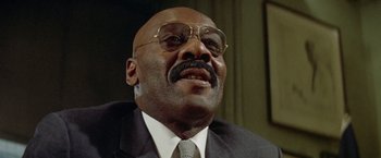 Movie still from “Shaft's Big Score!” (1972), directed by Gordon Parks – An older man wearing a suit and tie; Close Up shot, Low angle