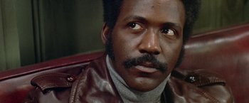 Movie still from “Shaft's Big Score!” (1972), directed by Gordon Parks – A person wearing a leather jacket; Close Up shot, Low angle