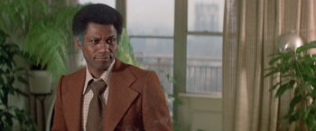 Movie still from “Shaft's Big Score!” (1972), directed by Gordon Parks – A person wearing a suit and a tie; Close Up shot, Low angle