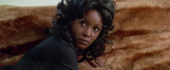 Movie still from “Shaft's Big Score!” (1972), directed by Gordon Parks – A woman with long black hair laying on the ground; Close Up shot, High angle