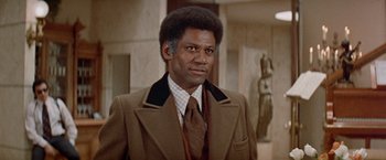 Movie still from “Shaft's Big Score!” (1972), directed by Gordon Parks – A person wearing a suit and tie; Close Up shot, Low angle