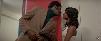 Movie still from “Shaft's Big Score!” (1972), directed by Gordon Parks – A man and a woman are standing next to each other; Medium shot, Low angle