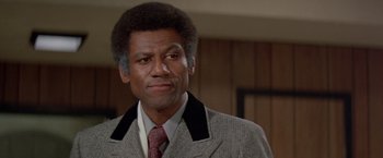 Movie still from “Shaft's Big Score!” (1972), directed by Gordon Parks – A person wearing a suit and tie; Close Up shot, Low angle