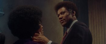 Movie still from “Shaft's Big Score!” (1972), directed by Gordon Parks – A man and a woman in a suit and tie looking at each other; Close Up shot, Over the shoulder angle