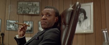 Movie still from “Shaft's Big Score!” (1972), directed by Gordon Parks – A man sitting in a leather chair in a room; Close Up shot, Low angle