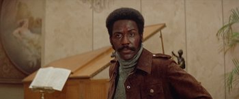 Movie still from “Shaft's Big Score!” (1972), directed by Gordon Parks – A man in a brown leather jacket and a sweater; Close Up shot, Low angle