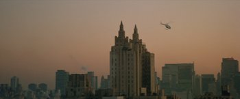 Movie still from “Shaft's Big Score!” (1972), directed by Gordon Parks – An airplane flying over a large building in a city; Extreme Wide shot, Low angle