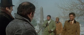 Movie still from “Shaft's Big Score!” (1972), directed by Gordon Parks – A group of men standing next to each other on top of a hill; Medium shot, Over the shoulder angle
