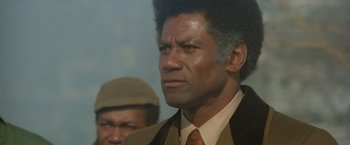 Movie still from “Shaft's Big Score!” (1972), directed by Gordon Parks – A man with a beard and a suit and tie; Close Up shot, Low angle