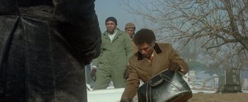 Movie still from “Shaft's Big Score!” (1972), directed by Gordon Parks – A group of men standing next to each other on a field; Medium shot, Low angle