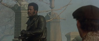 Movie still from “Shaft's Big Score!” (1972), directed by Gordon Parks – A man standing in front of a tree in the fog; Medium shot, Low angle