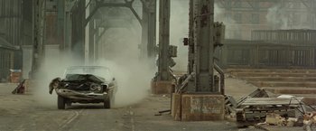 Movie still from “Shaft's Big Score!” (1972), directed by Gordon Parks – An old car driving down a street near a bridge; Wide shot, High angle