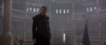 Movie still from “Shakespeare in Love” (1998), directed by John Madden – A man standing in front of an old building; Medium shot, Low angle