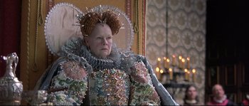 Movie still from “Shakespeare in Love” (1998), directed by John Madden – An older woman wearing a costume and a crown; Close Up shot, Over the shoulder angle