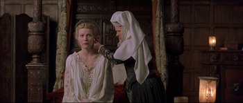 Movie still from “Shakespeare in Love” (1998), directed by John Madden – A woman in medieval garb putting a veil on another woman's face; Medium shot, Low angle