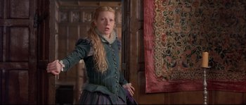 Movie still from “Shakespeare in Love” (1998), directed by John Madden – A woman in a green and purple dress standing in front of a wall; Medium shot, Over the shoulder angle