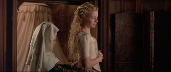 Movie still from “Shakespeare in Love” (1998), directed by John Madden – A woman with long blonde hair standing in front of a mirror; Medium shot, Over the shoulder angle