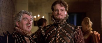 Movie still from “Shakespeare in Love” (1998), directed by John Madden – A man with a beard and a wig in a costume; Close Up shot, Low angle