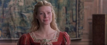 Movie still from “Shakespeare in Love” (1998), directed by John Madden – A woman with long blonde hair wearing a red dress; Close Up shot, Over the shoulder angle