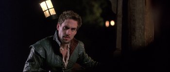 Movie still from “Shakespeare in Love” (1998), directed by John Madden – A man wearing a green and brown jacket; Close Up shot, Over the shoulder angle