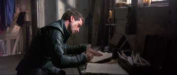 Movie still from “Shakespeare in Love” (1998), directed by John Madden – A man writing on a piece of paper; Medium shot, High angle