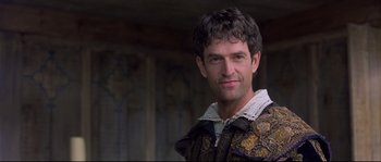 Movie still from “Shakespeare in Love” (1998), directed by John Madden – A person wearing a suit; Close Up shot, Over the shoulder angle