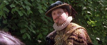Movie still from “Shakespeare in Love” (1998), directed by John Madden – A man wearing a hat and a suit; Close Up shot, Over the shoulder angle