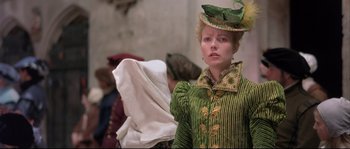 Movie still from “Shakespeare in Love” (1998), directed by John Madden – A woman in a green and yellow dress and hat; Medium shot, Over the shoulder angle