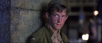 Movie still from “Shakespeare in Love” (1998), directed by John Madden – A young man wearing a hat is leaning against a wall; Close Up shot, High angle