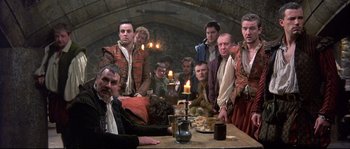 Movie still from “Shakespeare in Love” (1998), directed by John Madden – A group of people sitting around a table; Wide shot, High angle