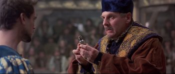 Movie still from “Shakespeare in Love” (1998), directed by John Madden – An old man holding a bottle in his hands; Close Up shot, High angle