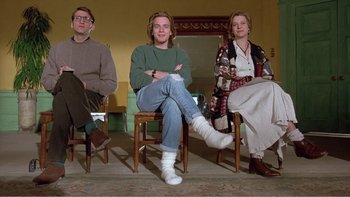 Movie still from “Shallow Grave” (1994), directed by Danny Boyle – A group of people sitting on chairs in a room; Wide shot, Low angle