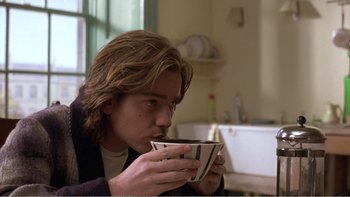 Movie still from “Shallow Grave” (1994), directed by Danny Boyle – A man is drinking a cup of coffee in a kitchen; Close Up shot, Low angle